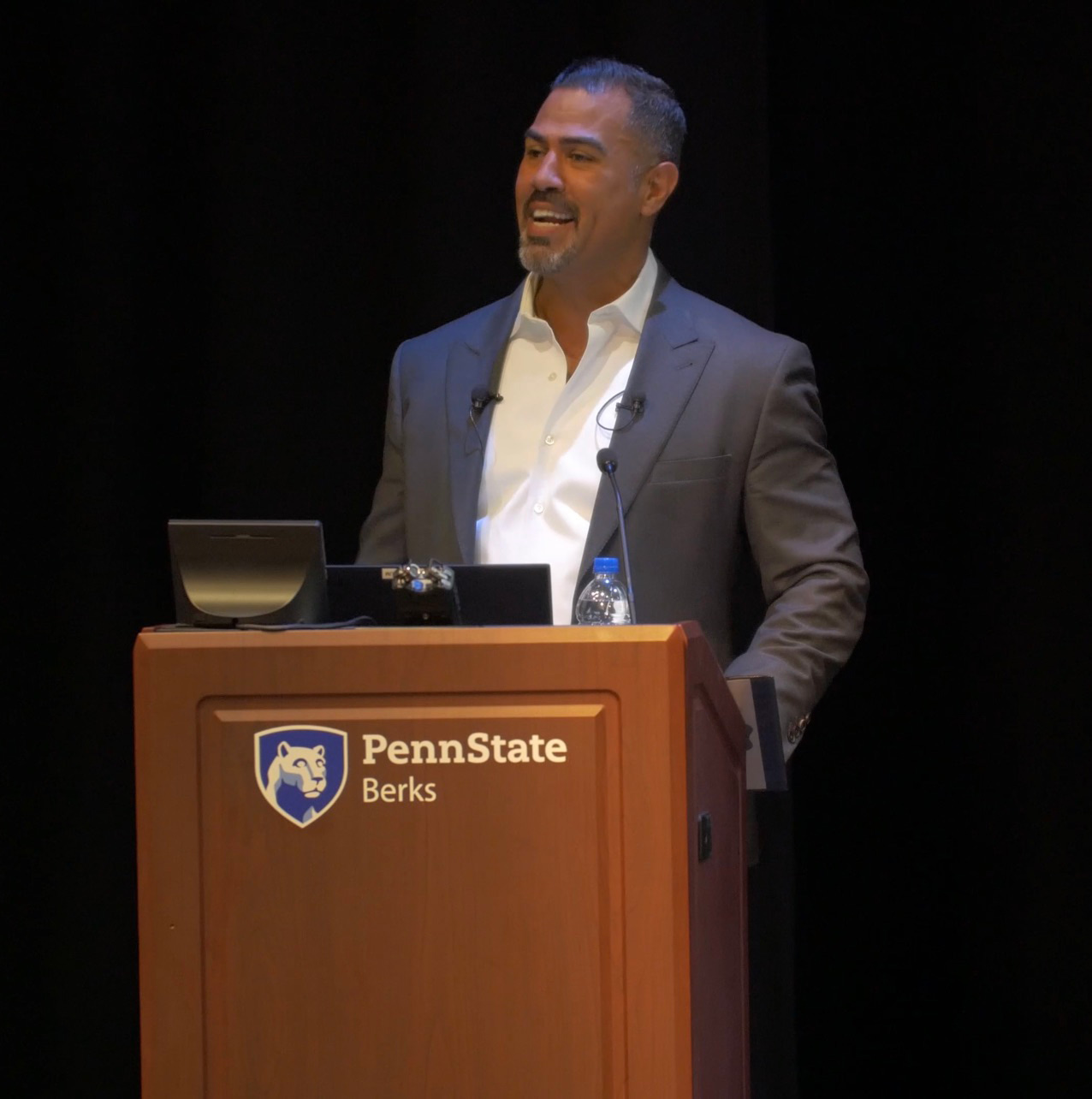 J.W. standing behind a podium speaking.