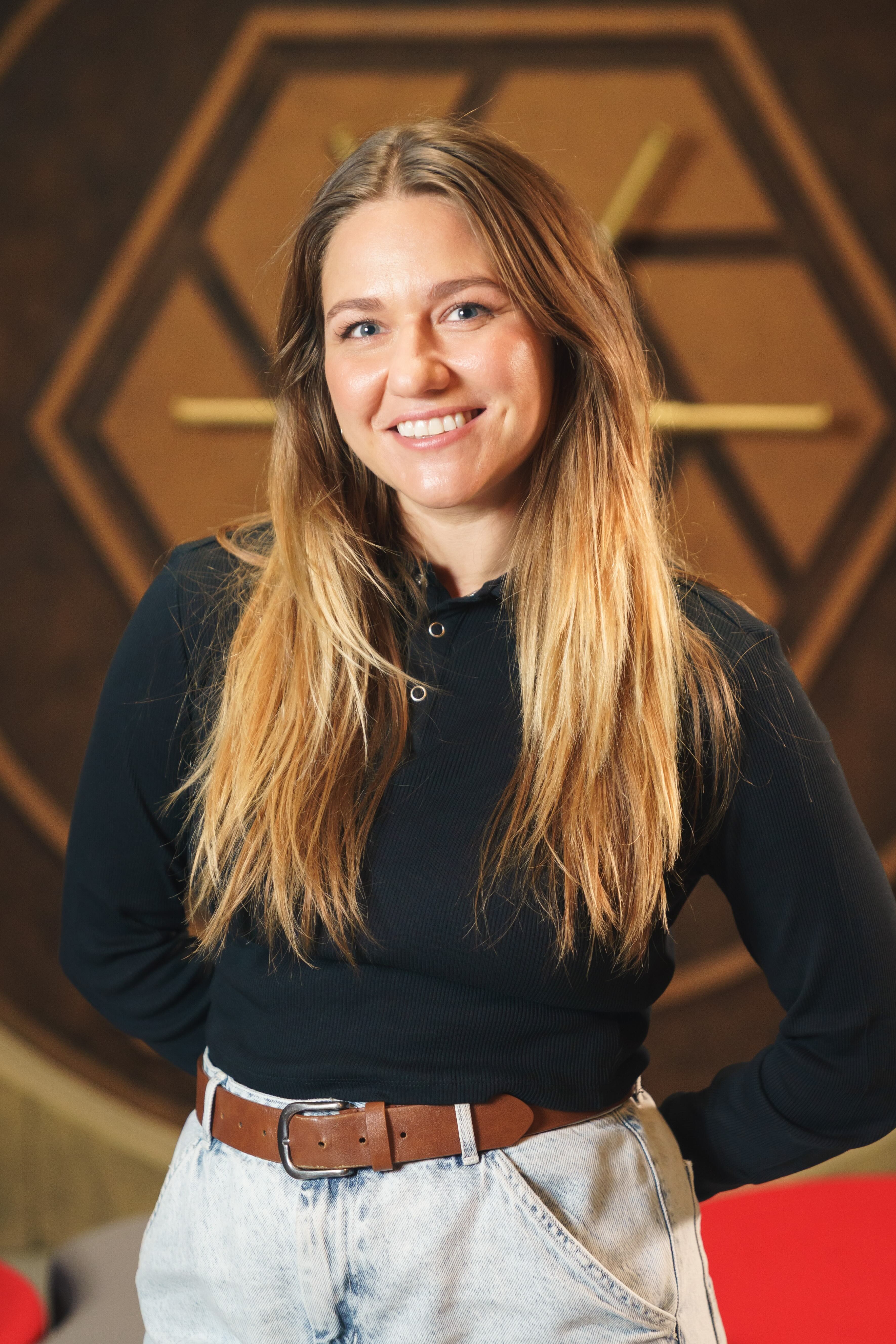 Photo of Lauren Huggins standing with her arms behind her back.